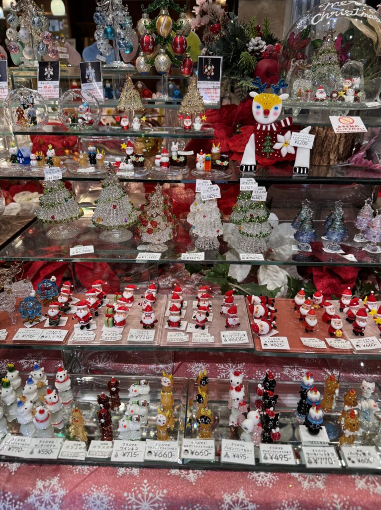 A display of Christmas-themed figurines, with a variety of small, colorful decorations