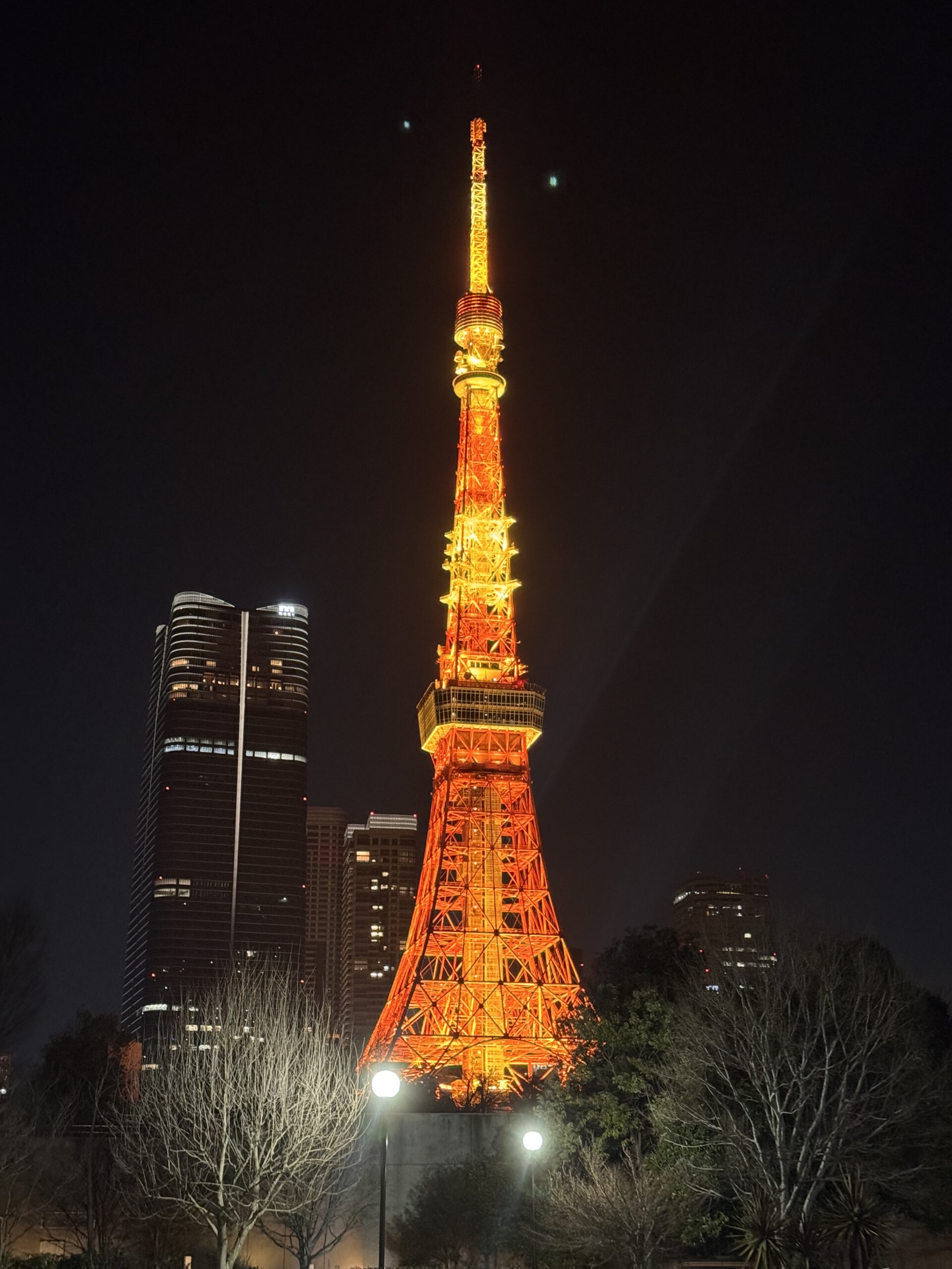 Tokyo Tower illuminated in warm orange lights against the night sky