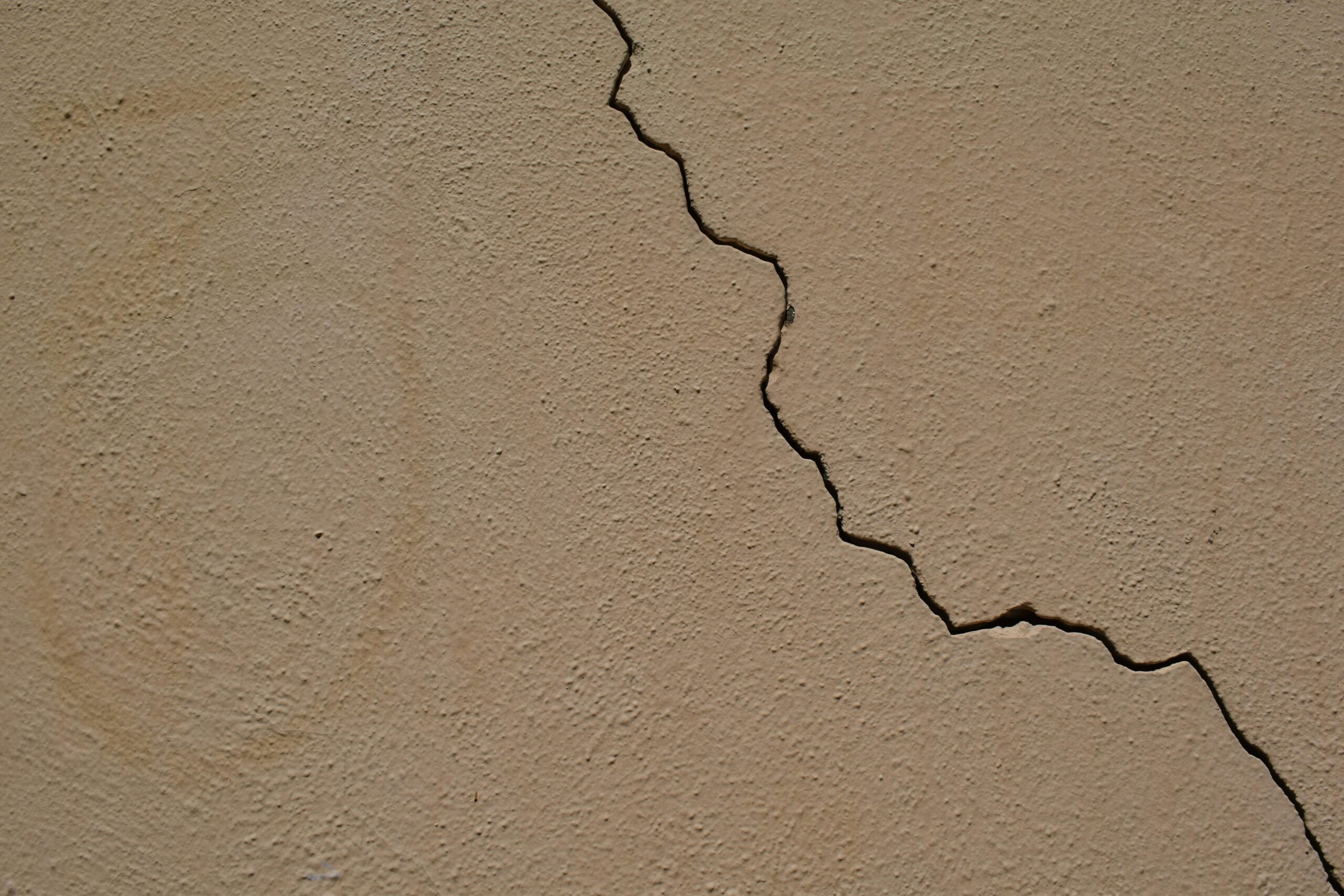 English: Close-up of a cracked beige wall showing the quiet beauty in imperfection, photographed by Marija Zaric on Unsplash. Korean: 불완전함 속 고요한 아름다움을 담은 균열진 베이지색 벽의 클로즈업 사진. Unsplash의 Marija Zaric 작가 촬영.