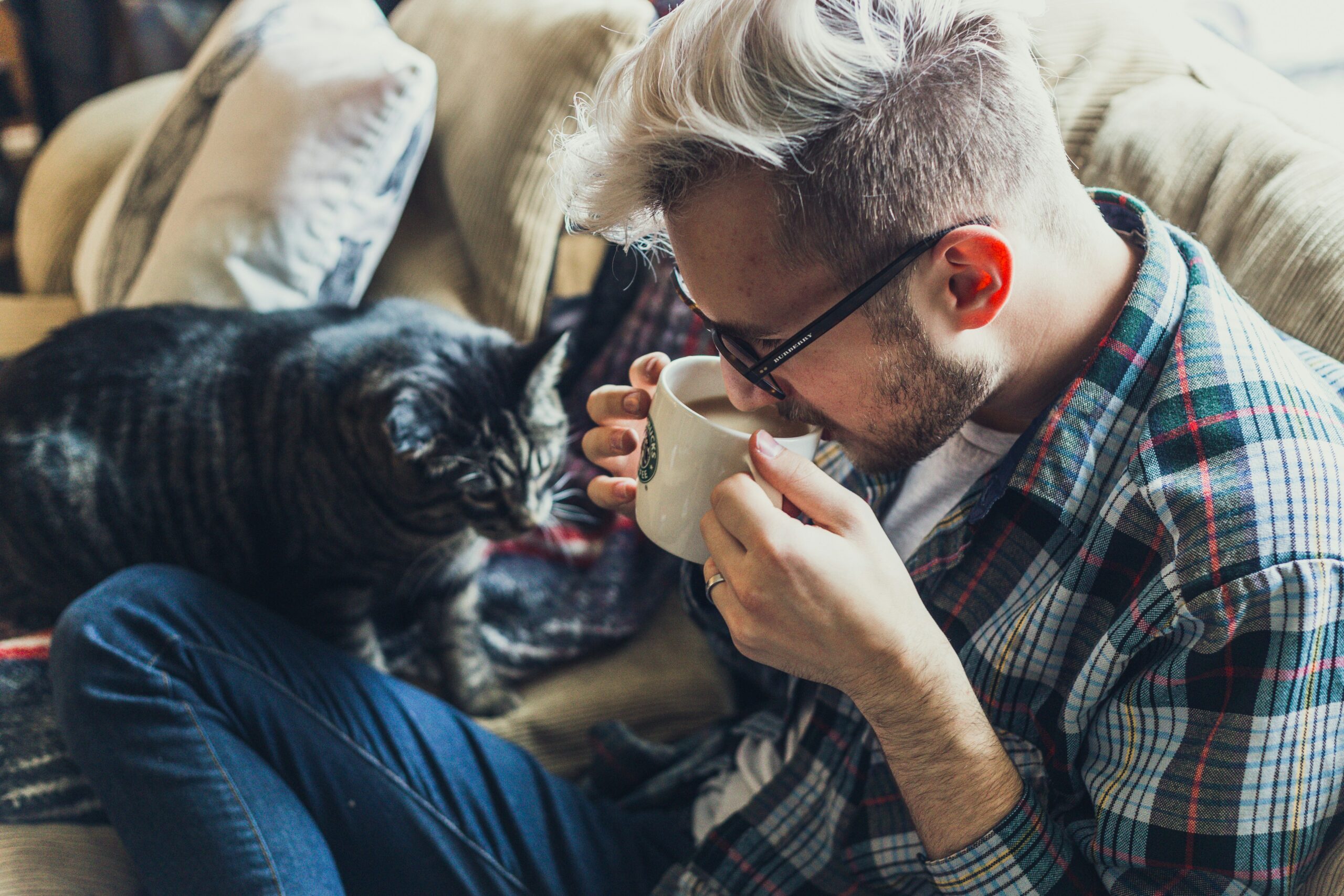 A man holding a cup of coffee while sitting with his cat — a quiet morning that captures the warmth of ordinary life. 고양이와 함께 커피를 마시는 남자 — 평범한 일상 속 따뜻한 아침의 한 장면.